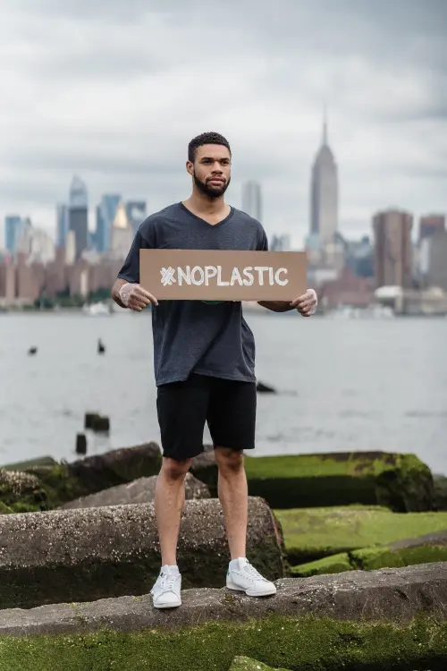 A man holding a sign saying #noplastic